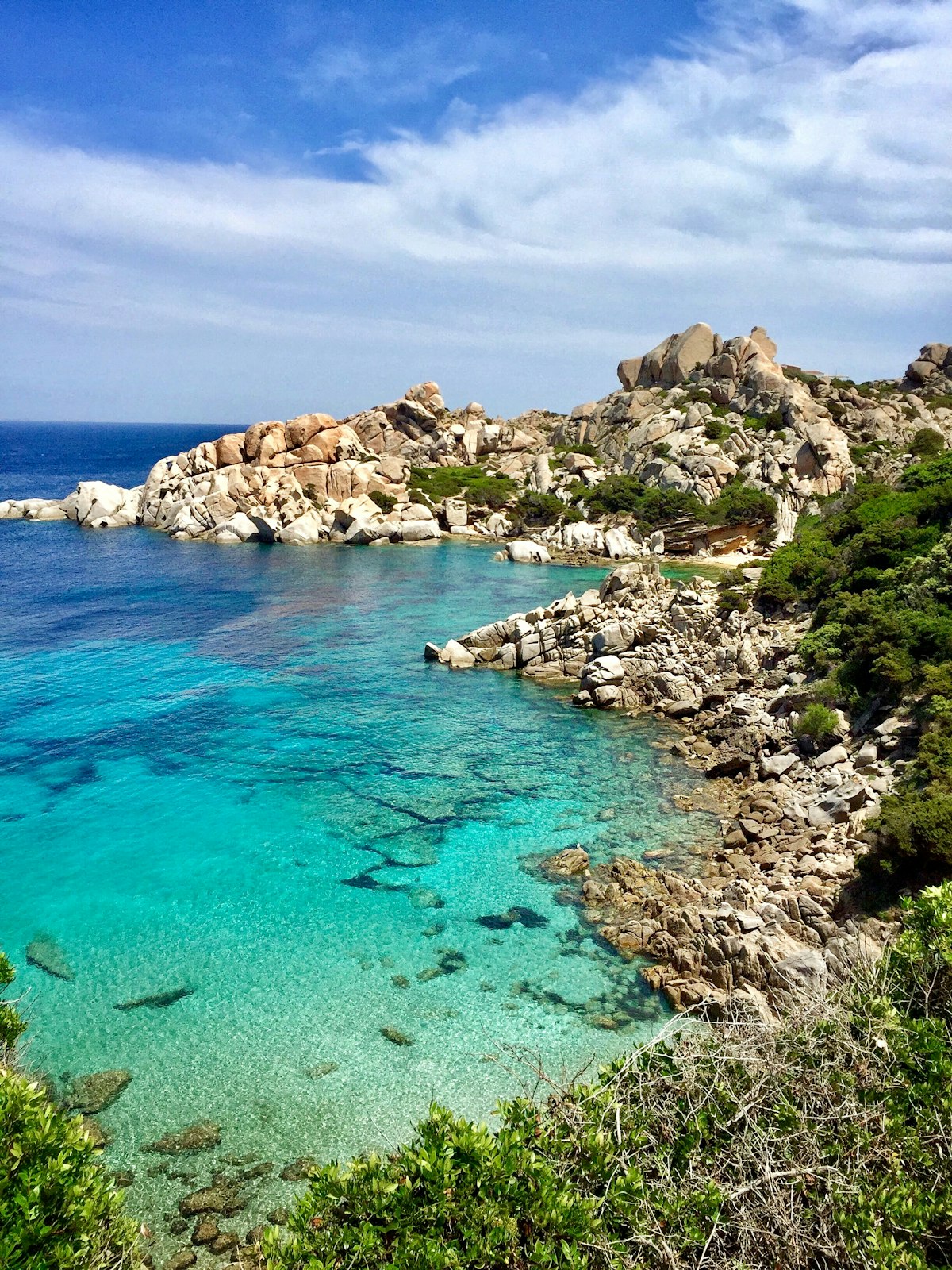 Turquoise cove surrounded by rocks and trees in Sardinia